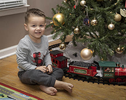 Boy with Christmas tree and train